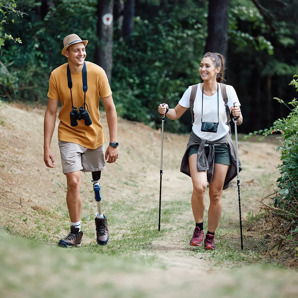 man with prosthetic leg and woman hiking